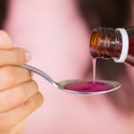 Woman,Hand,Pouring,Medication,Or,Antipyretic,Syrup,From,Bottle,To